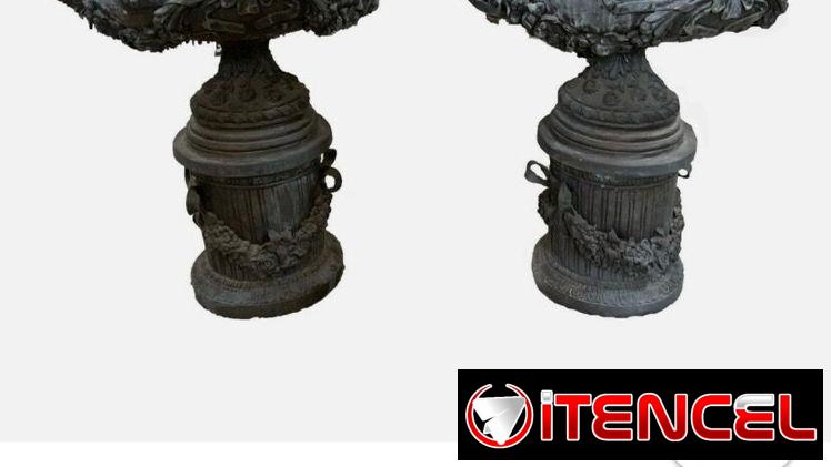 Urna de bronce vintage con detalles de flores y volutas sobre pedestal