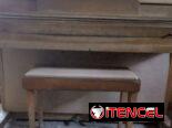 Piano acústico Wurlitzer con su banqueta portalibros, ideal para estudio.