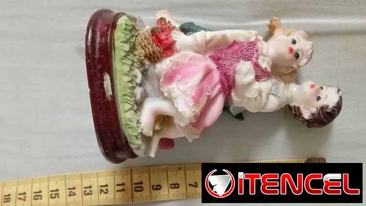Adorno de cerámica. Pareja de jóvenes recostados en el césped